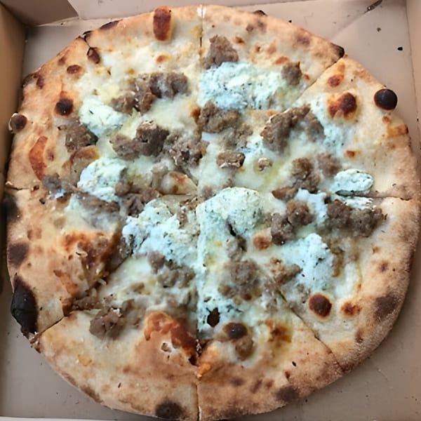 CraveN Pizza's white pizza with sausage and ricotta cheese, sliced in a delivery box.